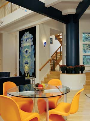 Artist Anthony Brock's "Body of Paint" on recycled plastic hangs as if it were designed specifically for the space. The glass table and recyclable Panton chairs were purchased through Design Within Reach.